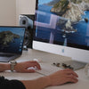 person using silver imac and apple keyboard