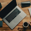 macbook pro beside black iphone 5 on brown wooden table