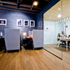 an office with a glass wall and wooden floors