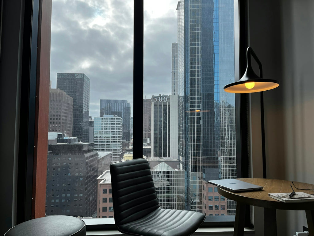 a chair and a table in a room with a view of a city