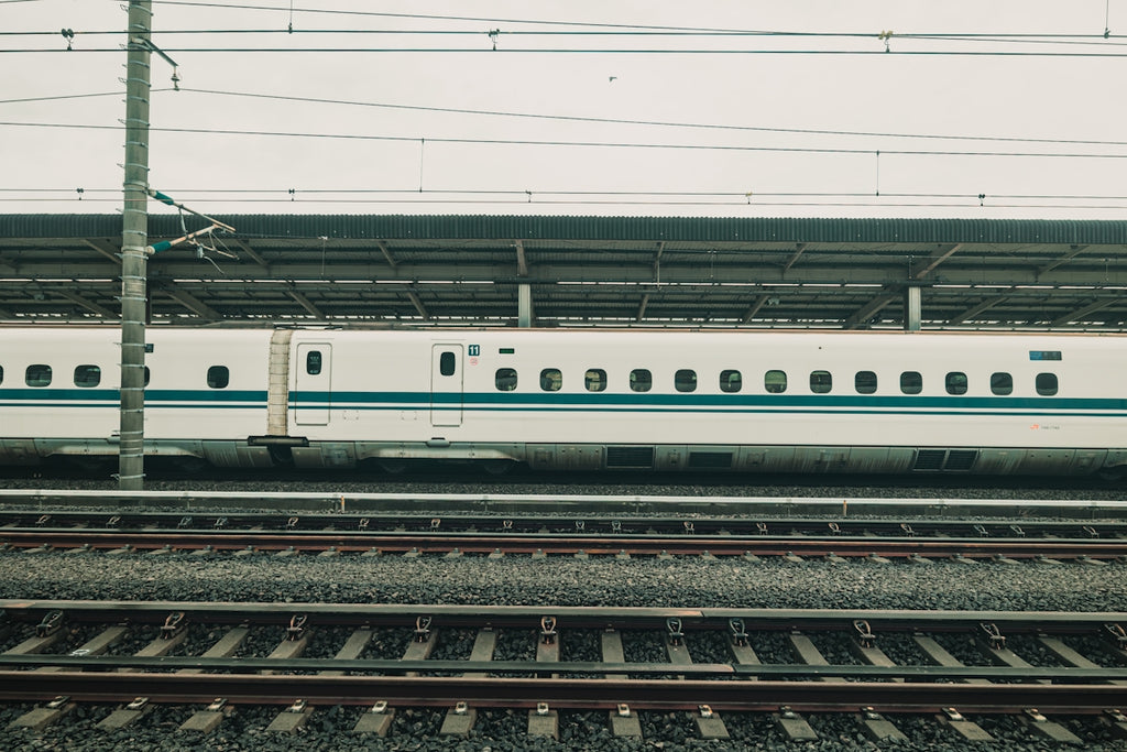 White bullet train at a station platform.