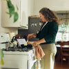 Woman cooking on a stovetop in a kitchen