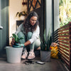 Woman planting a small houseplant in a pot.