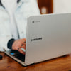 shallow focus photography of person using gray Samsung laptop