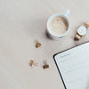 white printer paper beside filled mug