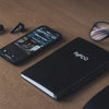 black lenovo laptop computer beside black smartphone on brown wooden table