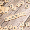 scrabbled letters spelling growth on a wooden surface