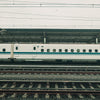 White bullet train at a station platform.